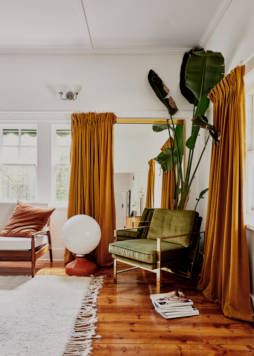 burnt orange and rust hued home with olive arm chair and indoor plant