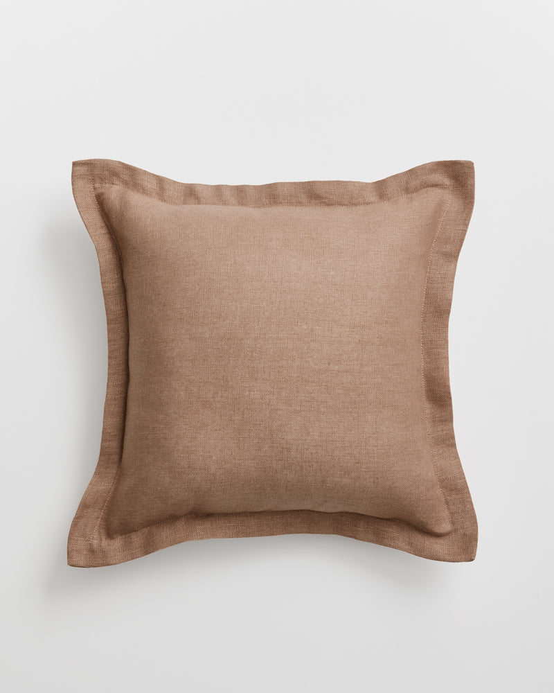 A square cushion cover in a warm taupe-brown 100% french flax linen fabric with a matching border, shown against a light grey background.