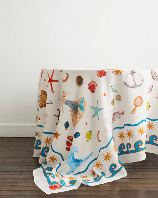 Decorative tablecloth with nautical-themed patterns on a wooden floor.