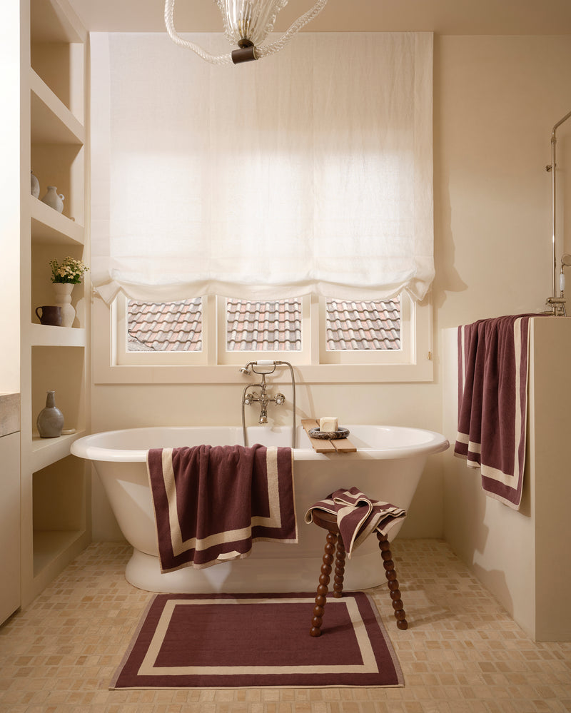 Neutral bathroom with freestanding bath tub and cotton terry towels in a cacao colour with creme border.
