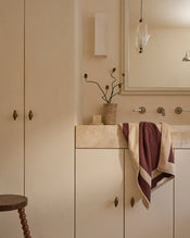 Neutral bathroom with cotton terry hand towel in cacao & creme hanging near sink. - view