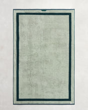 The Bed Threads Forest & Sage Two-Toned 100% Cotton Terry Bath Sheet Bundle features a rectangular, light gray-green luxury towel with a dark green double border, shown flat on a light surface. - view