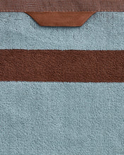 Close-up of the Bed Threads Cacao & Lagoon Two-Toned 100% Cotton Terry Bath Sheet Bundle, featuring plush light blue textured fabric, a horizontal brown stripe, and a brown loop at the top edge. - view
