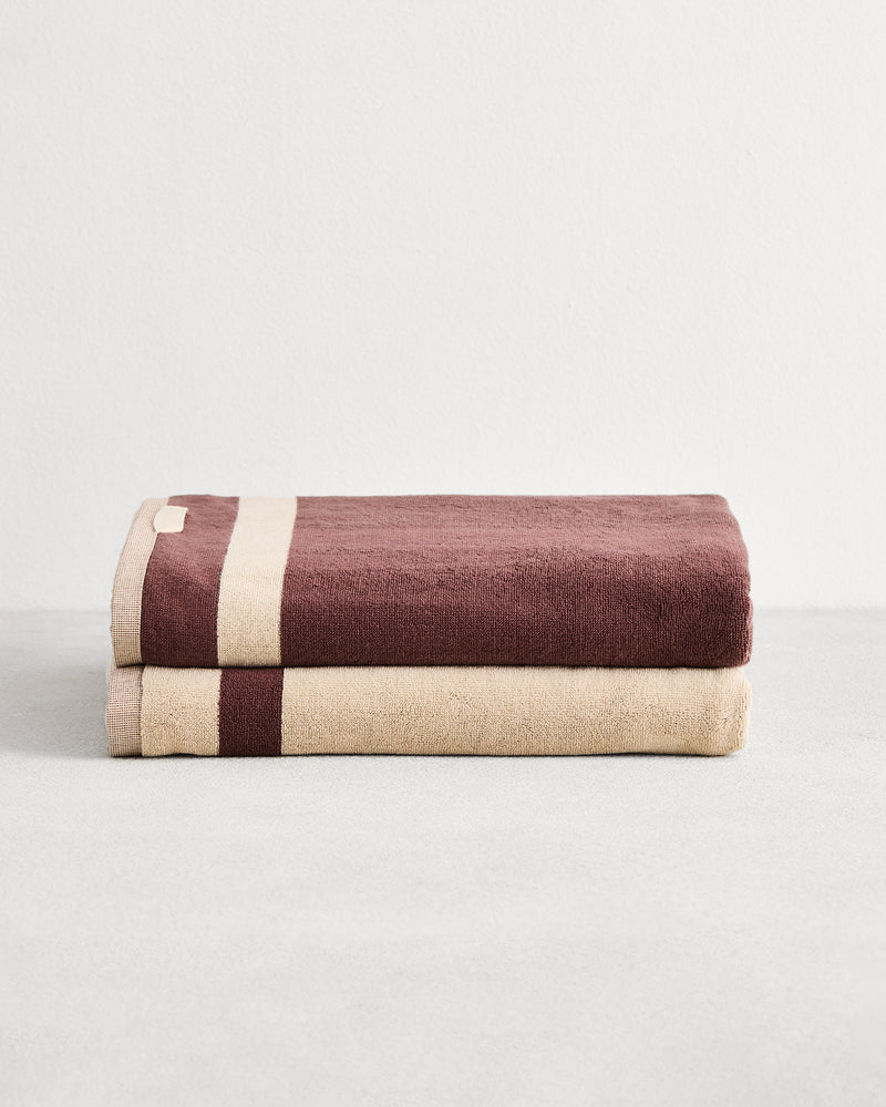 Stack of two cotton terry bath sheets in reversible colours creme and cacao. 