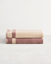 Stack of two cotton terry bath sheets in reversible colours creme and lavender.  - view