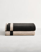 Stack of two cotton terry bath sheets in reversible colours oatmeal and charcoal. - view