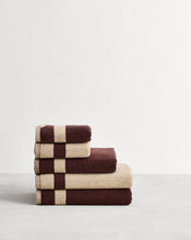 Stack of cotton terry bath towels in reversible colours creme and cacao.  - view