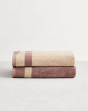 Stack of two cotton terry bath towels in reversible colours creme and lavender.  - view