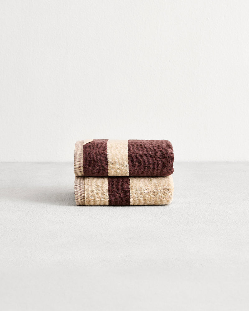 Stack of two cotton terry hand towels in reversible colours creme and cacao. 