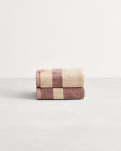 Stack of two cotton terry hand towels in reversible colours creme and lavender.  - view